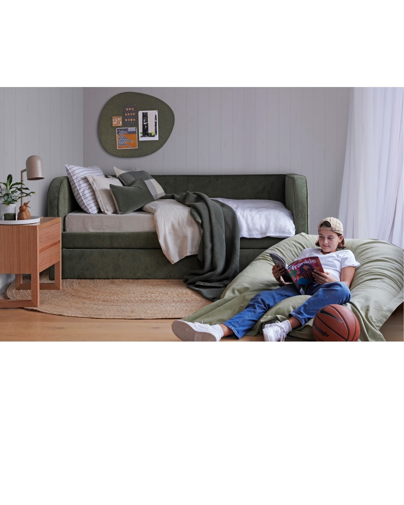 Relaxed Teens Bedroom featuring a green day bed and felt pebble pinboard on the wall.