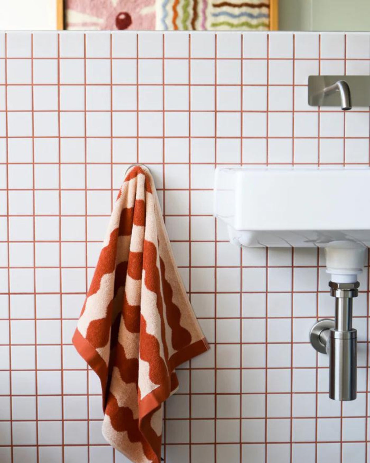 The Wiggle hand towel is the perfect print to bring a sophisticated and fun vibe to your bathroom. This graphic print in rust and peach is designed&nbsp;for luxury. These ultra-plush hand towels are made from 100% organic cotton for the dreamiest feel against your kids delicate skin.