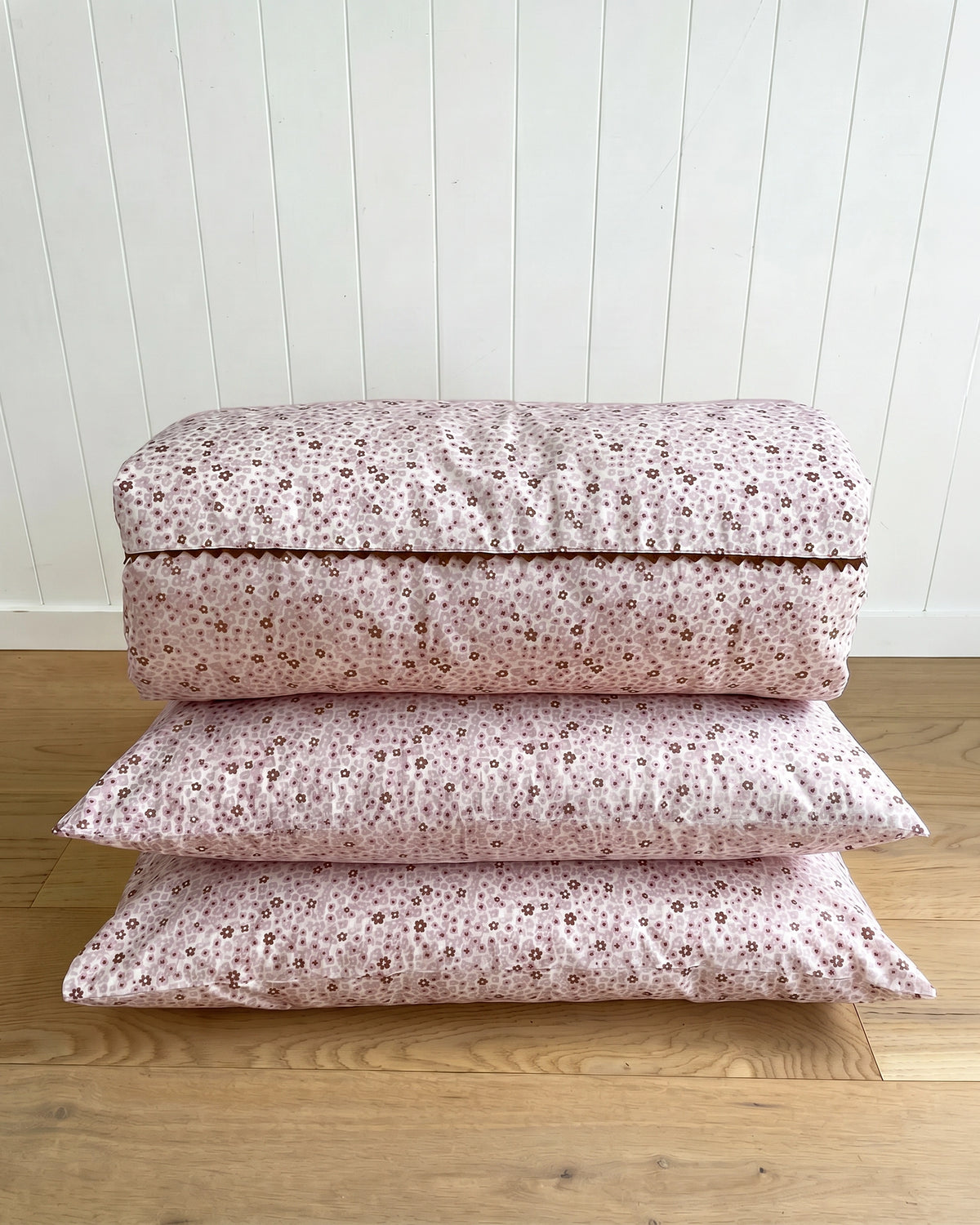 The Daisy Pillowcase features a whimsical all-over daisy print in soft dusty pink and rich cocoa tones. Available in a set of 2.