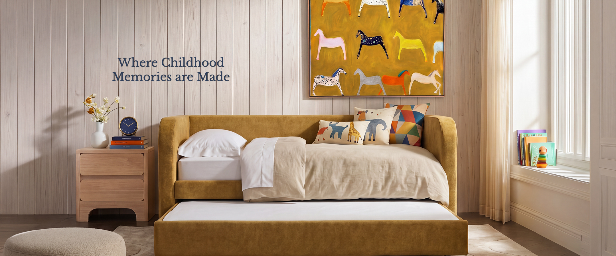 A mustard yellow upholstered daybed in a styled kid's bedroom setting, featuring a matching wooden bedside table a colorful horse painting on the wall, and the text 'Where Childhood Memories are Made' on the wood-paneled wall.