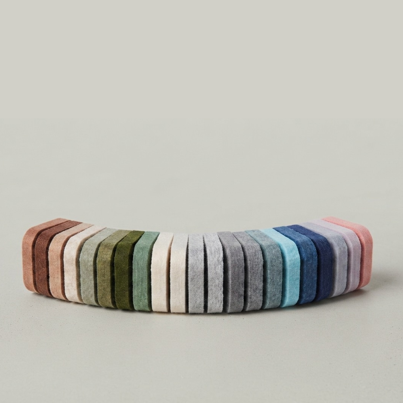 A curved row of felt pinboard swatches in assorted colours, including pink, blue, grey, olive, sage and stone. Free samples posted to you.