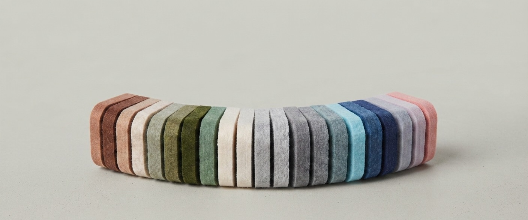 A curved row of felt pinboard swatches in assorted colours, including pink, blue, grey, olive, sage and stone. Free samples posted to you.